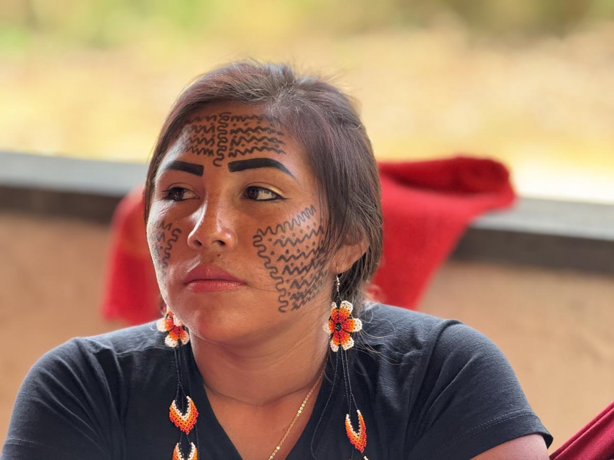 Adailsa Yanomami, participante da oficina de Direitos Humanos para mulheres, aparece sentada. Ela tem o rosto pintado