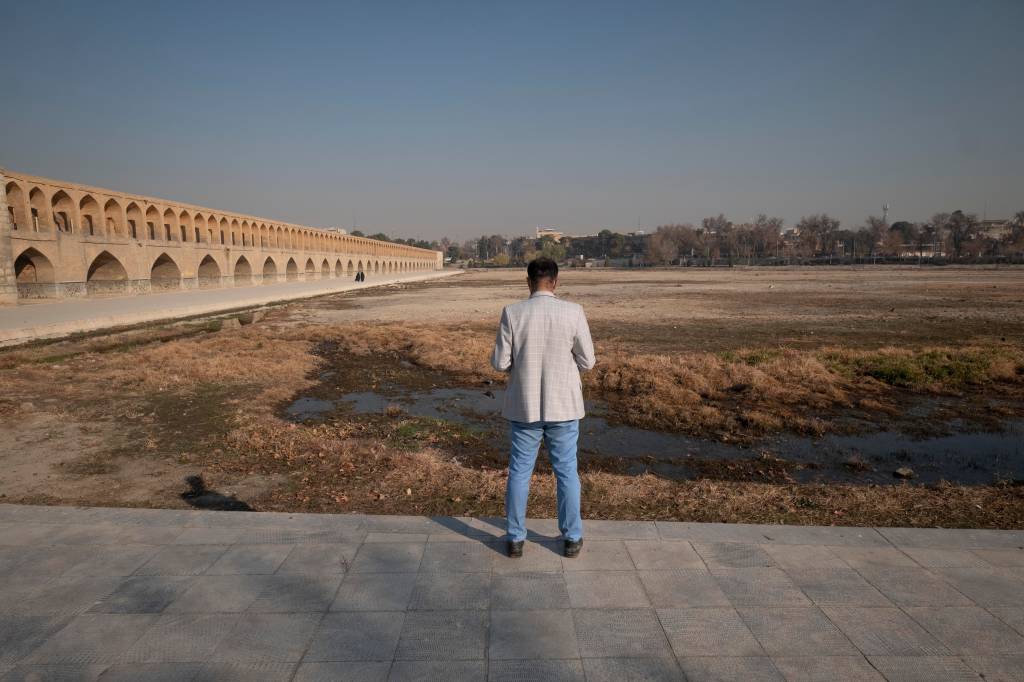 Iraniano observa a margem seca do rio Zayandeh Rud, na cidade de Isfahan, a 450 km ao sul de Teerã Iraniano observa a margem seca do rio Zayandeh Rud, na cidade de Isfahan, a 450 km ao sul de Teerã